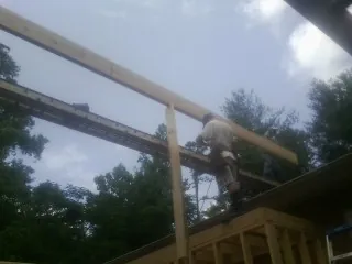 Carpenter setting a ridge beam over a new addition frame — Ice Dam Removal by Roofing Brothers in Brookston