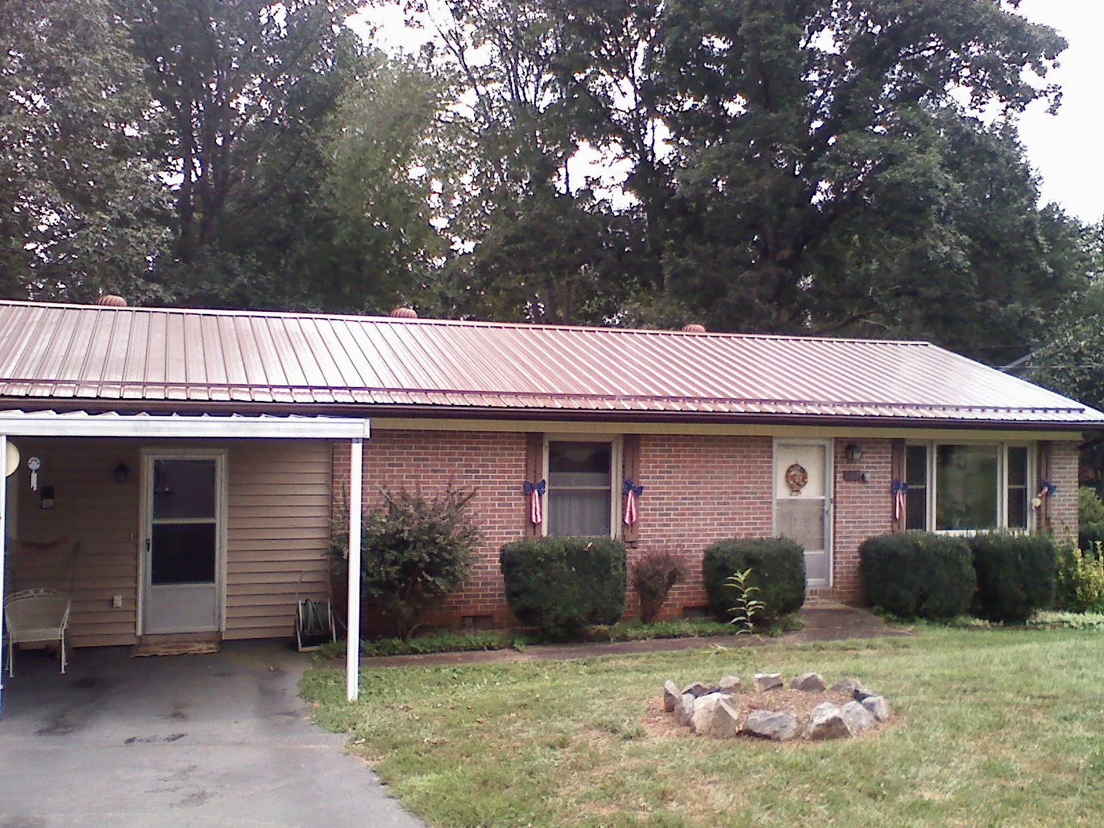 Bronze metal roof and carport on a brick ranch home — Roof Repair work by our crew in Brookston